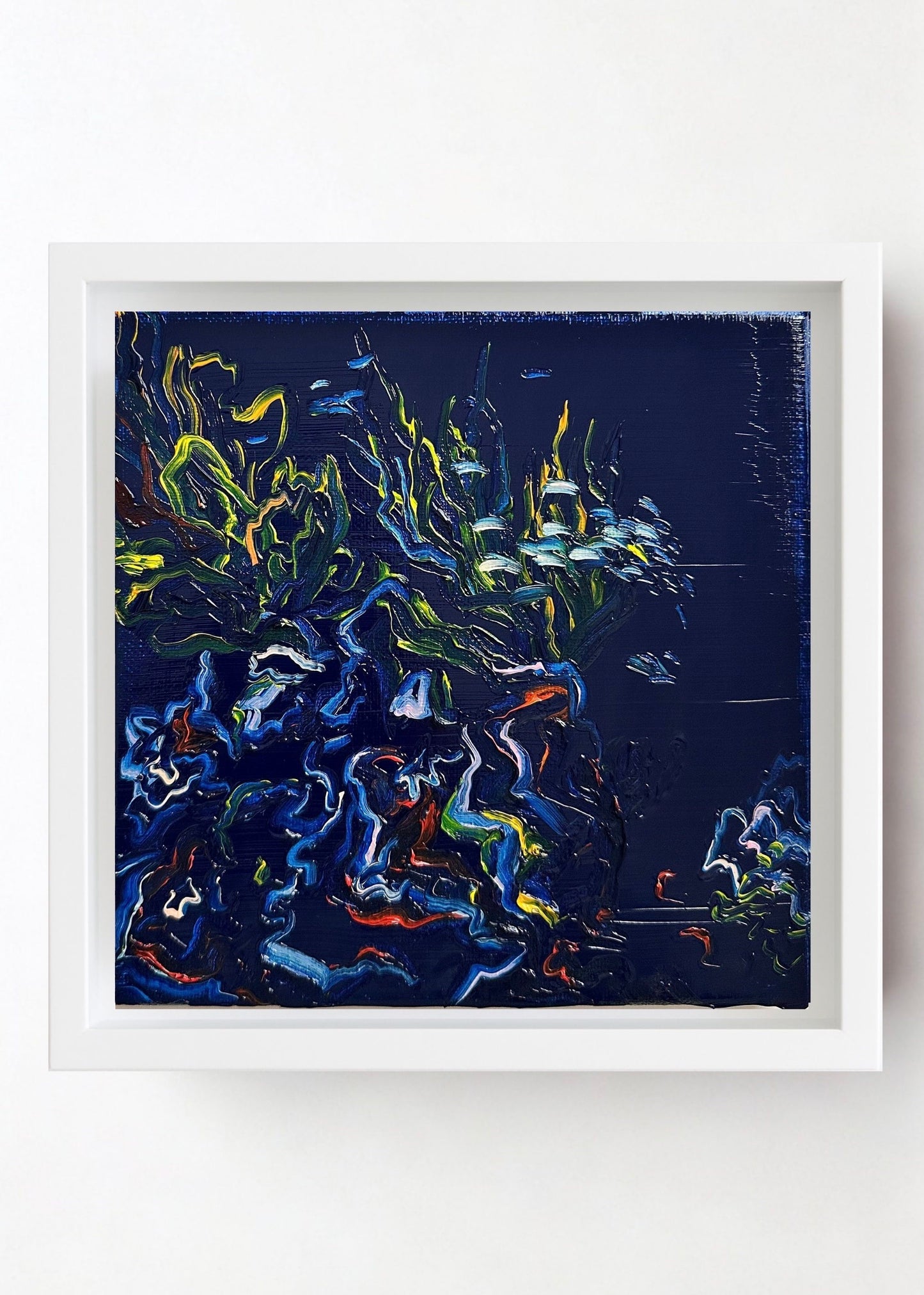 Framed Oil Painting of a small coral branch with fish swimming around it and dynamic colors on a dark background.